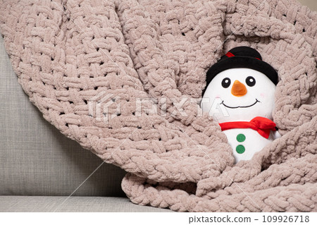 Toy stuffed snowman basking in pink plush blanket in winter 109926718