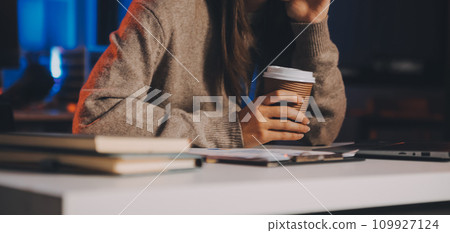 Team of software developers working on big project late at night in neon light trying to finish before deadline 109927124