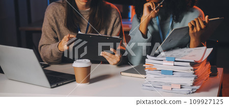 Team of software developers working on big project late at night in neon light trying to finish before deadline 109927125