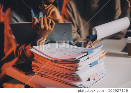 Team of software developers working on big project late at night in neon light trying to finish before deadline 109927126