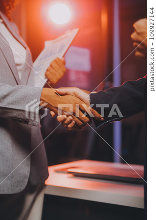 Team of software developers working on big project late at night in neon light trying to finish before deadline Team of software developers working on big project late at night in neon light trying to finish before deadline 109927144