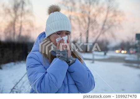 Girl wipes nose with handkerchief during winter walk 109927470