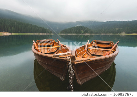 Two Rowboats on Morning Mountain Lake with Fog 109927673