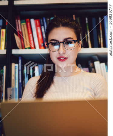 Young female student using laptop in library Young female student using laptop in library 109929777