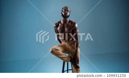 Black bearded gay wearing make-up sitting chair 109931250