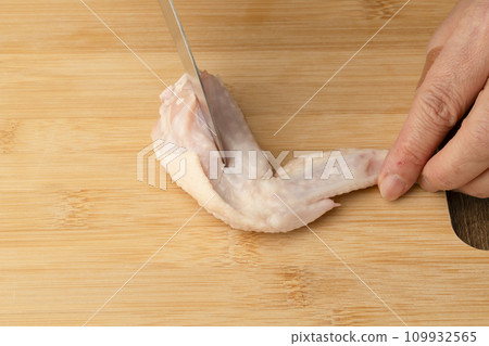 Cut chicken wings with a knife Cut chicken wings with a knife 109932565