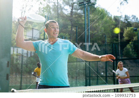 Man playing padel tennis on court 109932753