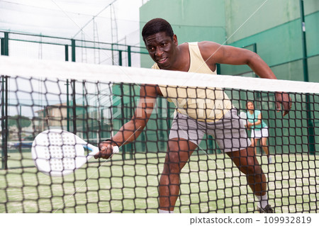 Sporty emotional man playing doubles paddle tennis 109932819