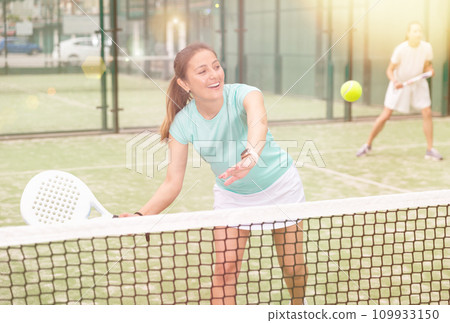 Young emotional women playing paddle tennis outdoors 109933150
