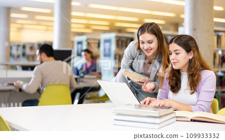 Portrait of two woman working in university library 109933332