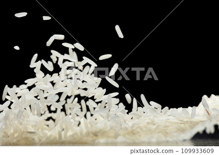 Japanese Rice flying explosion, white grain rices fall abstract fly. Beautiful complete seed jasmine rice splash in air, food object design. Black background isolated selective focus blur 109933609