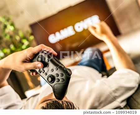 man playing video games at home man playing video games at home 109934019