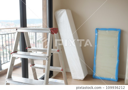 Metal ladder standing in empty room, renovation and improvement concept. Metal ladder standing in empty room, renovation and improvement concept. 109936212