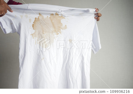 women holding white color dirty shirt, showing making stain women holding white color dirty shirt, showing making stain 109936216