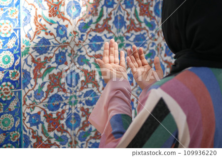 Muslim young woman in hijab is praying in mosque. 109936220