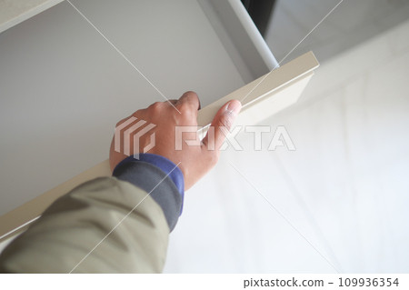 man's hand open drawer wooden in cabinet 109936354