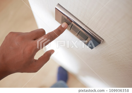 A finger turning on lighting switch . 109936358