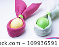 Easter eggs and the shape of rabbit ears, on a white background, selective focus, tinted image 109936591