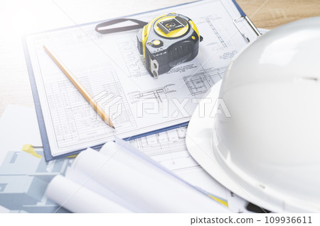 white helmet and tape measure, pencil ruler and construction drawings, selective focus, tinted image, construction concept repair and reconstruction of buildings and structures white helmet and tape measure, pencil ruler and construction drawings, selective focus, tinted image, construction concept repair and reconstruction of buildings and structures 109936611