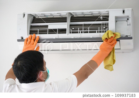 Asian man cleaning air conditioner with microfiber cloth Asian man cleaning air conditioner with microfiber cloth 109937183