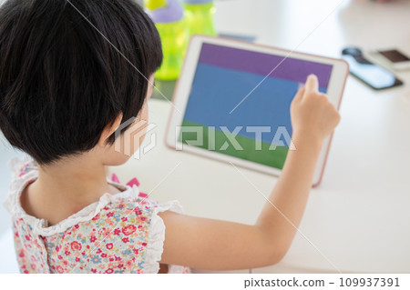 Little asian girl playing digital tablet at home 109937391