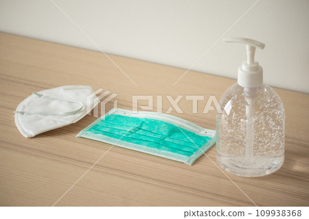 Medical face mask with alcohol sanitizer gel hand wash on wood table for covid-19 Coronavirus prevention concept 109938368