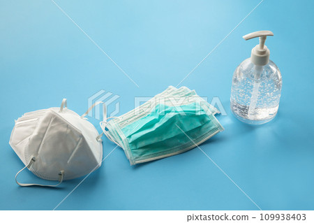 Alcohol sanitizer gel hand wash bottle with N95 Medical face mask on blue background covid-19 Coronavirus prevention concept Alcohol sanitizer gel hand wash bottle with N95 Medical face mask on blue background covid-19 Coronavirus prevention concept 109938403