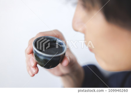 A man's hand drinking sake A man's hand drinking sake 109940260