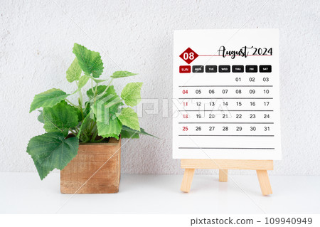 August 2024 calendar page and wooden plant pot on the table. 109940949