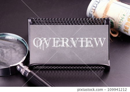 OVERVIEW text on the business card next to the money, a magnifying glass on a black background 109941212