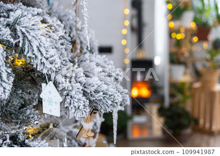 Key to the house with a keychain is hanging on the Christmas tree. A gift for New Year, Christmas. Building, design, project, moving to new house, mortgage, rent and purchase real estate. Copy space Key to the house with a keychain is hanging on the Christmas tree. A gift for New Year, Christmas. Building, design, project, moving to new house, mortgage, rent and purchase real estate. Copy space 109941987