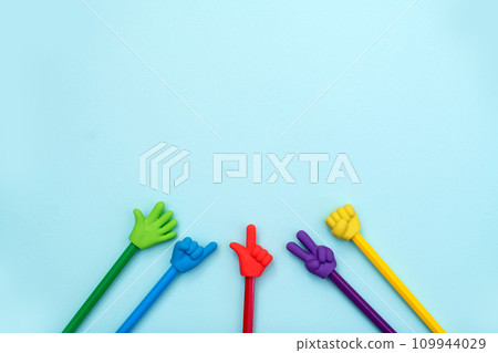 Colorful school erasers in the form of various gestures on colored pencils on a blue background. The concept of nonverbal communication, the expression and transmission of thoughts using symbols 109944029