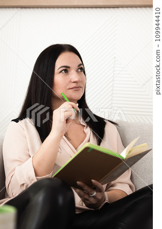 A girl takes notes on work in a notebook while sitting in the office 109944410