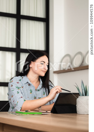 A girl in the office is working on a tablet 109944576