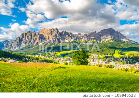 Panorama of Cortina d'Ampezzo with green meadows and alpine peaks on the background. Dolomites, Italy Panorama of Cortina d'Ampezzo with green meadows and alpine peaks on the background. Dolomites, Italy 109946528