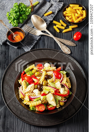 fusilli salad with mozzarella, veggies in a bowl 109947207