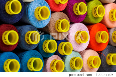 set of multi-colored spools of thread for sewing 109947406