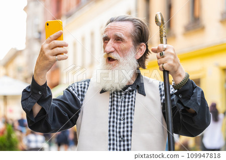Senior man use mobile smartphone celebrating win good message news outdoors in urban city street 109947818