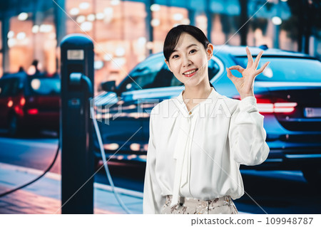Woman charging electric car on the road 109948787