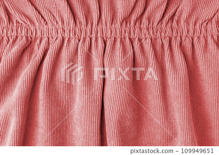 Red velveteen fabric with folds on elastic. Cloth background, velveteen texture. 109949651