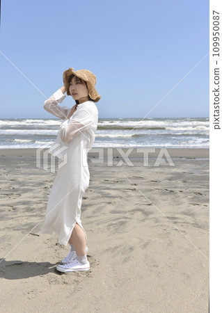 Young woman in a dress on the beach 109950087