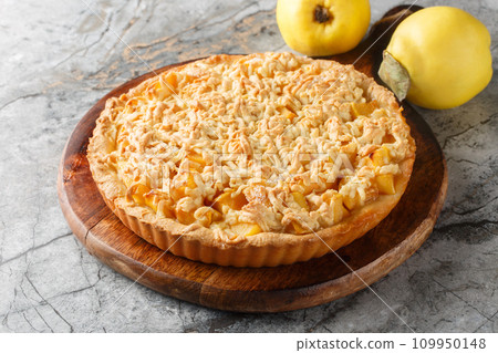 Crumble tart delicious combination of sweet, rich quince with streusel closeup on the wooden board. Horizontal Crumble tart delicious combination of sweet, rich quince with streusel closeup on the wooden board. Horizontal 109950148