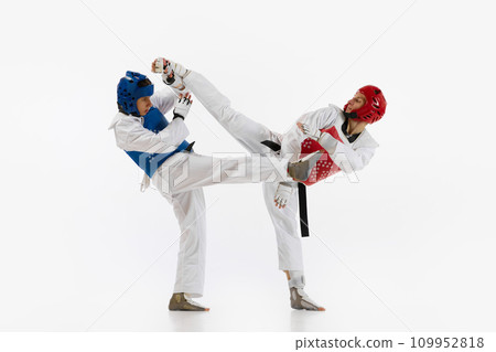 Athletic, motivated young men, taekwondo athletes in motion, practicing, training isolated over white background. Martial arts, combat sport 109952818