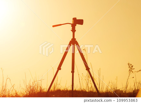 Silhouette of camera on tripod at sunset Silhouette of camera on tripod at sunset 109953863
