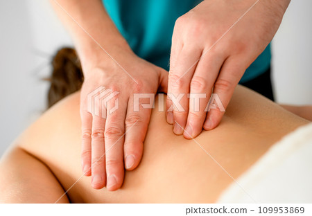 Massage therapist doing massage of trigger points in the back 109953869