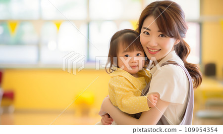 托兒所老師抱著一個孩子在室內 托兒所老師抱著一個孩子在室內 109954354