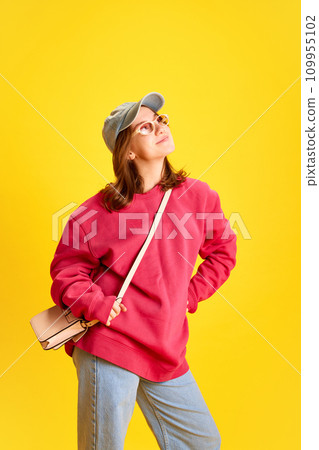 Full length portrait of happy cheerful student, tourist dressed oversized clothes and trendy sunglasses against vivid yellow background. 109955102
