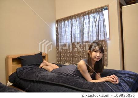 一個穿著裙子的年輕女子在床上放鬆 109956056