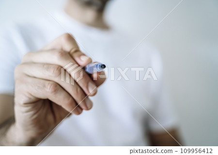 Hand with pen marker or pencil. Signature, drawing school concept background.  109956412