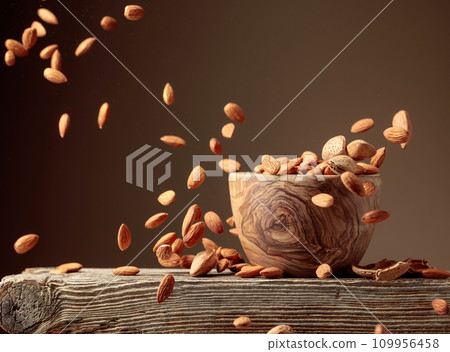 Almond is poured into a wooden bowl. Almond is poured into a wooden bowl. 109956458
